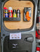 The van door interior features mounted shelves with spray cans and orange gloves, exemplifying efficient van racking. A brochure in a lower holder highlights the "Van Storage Racking Monthly Bundle Deal," showcasing the latest offer on essential van equipment.