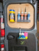 The interior door of a van features a well-organized storage system with wall-mounted compartments, showcasing van accessories like a General Purpose Metal Storage Box - Medium, various sealant tubes, spray cans, and other essential cleaning supplies.