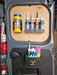 Inside of a van door equipped with the Van Storage Racking Monthly Bundle Deal, featuring mounted shelves that hold cleaning wipes, sealant tubes, gloves, and paper towels.